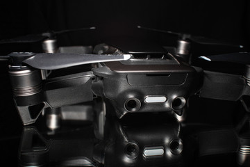 Camera drone with reflection on shiny black background