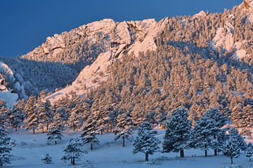 Winter landscape of the Flatirons flocked with snow at sunrise, Rocky Mountains, Boulder, Colorado, USA