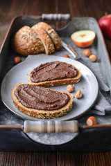 Healthy breakfast, slices of whole grain bread with apple spread made from cocoa powder, roasted ground hazelnuts and dark chocolate
