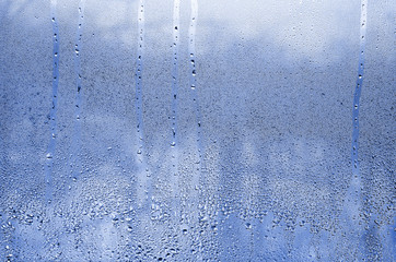 Texture of a drop of rain on a glass wet transparent background. Toned in phantom classic blue...