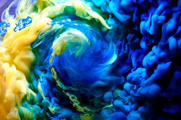 Abstract dancing colorful fume background. Clouds of smoke blue, green and yellow, a whirlwind of...