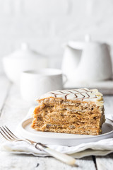 Traditional Hungarian Esterhazy piece of cake on a white wooden background.
