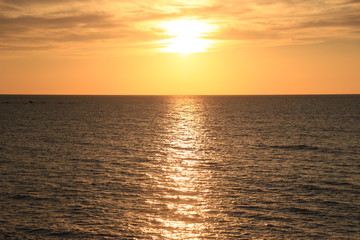佐渡の夕日　海がきらめき太陽が沈む写真素材