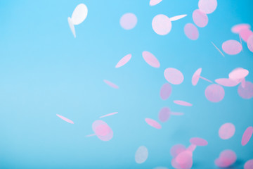 Orange and yellow falling confetti on blue background