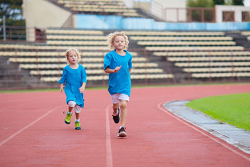 Fototapeta premium Child running in stadium. Kids run. Healthy sport.
