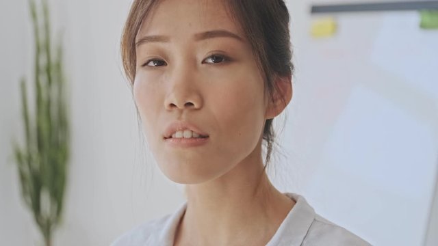 Cropped view of beautiful calm young asian business woman in the white office
