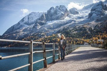 Fototapeta na wymiar Pretty Girl Walks by the Lake in the Dolomites