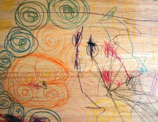 Wooden chair background picture in which a child in a mischievous age uses various colored pens to write in a messy pattern.
