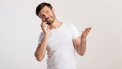 Man Talking On Cellphone Gesturing And Smiling On White Background