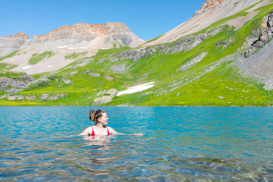 Young Happy Woman Girl Swimming In Cold Vibrant Water Of Ice Lake On Famous Trail In Silverton, Colorado In San Juan Mountains In Summer