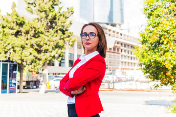 Business woman in glasses stands in the city. Portrait of a confident business woman.