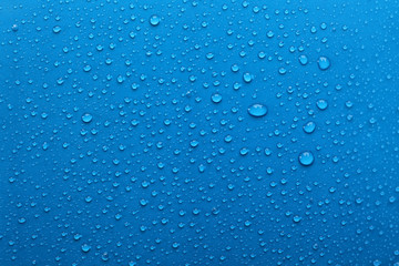 Water drops on light blue background, top view