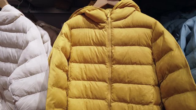 winter down jackets of different colors on the store shelf