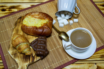 coffee with chocolate and a bun, top view, selective focus