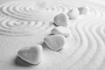 White stones on sand with pattern. Zen, meditation, harmony