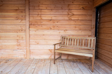 A wooden bench seat on a wooden porch, with wood roof close-up new interior modern