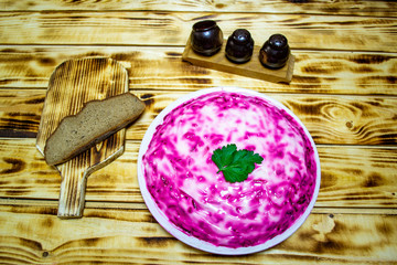 Russian cuisine, beet and herring salad, vinaigrette on a wooden table, top view, selective focus
