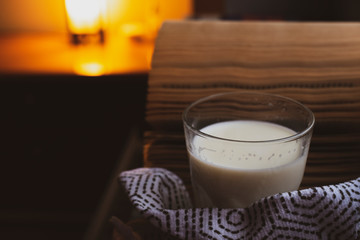 Hot cup of milk and books near the window on a rainy day. Self-care routine