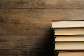 Collection of different books on wooden background. Space for text