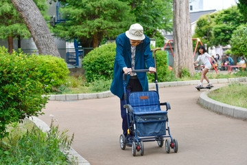 シルバーカーを押して散歩をする高齢者の女性　Elderly woman taking a walk