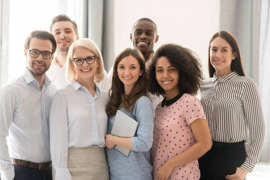 Smiling multiethnic employees posing together for group picture