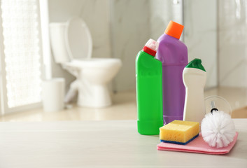 Cleaning supplies and toilet bowl in bathroom. Space for text