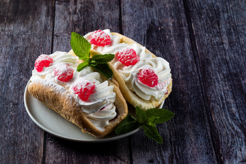 Airy raspberry cake in a plate on a wooden background