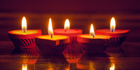 Colourful candles on the glass; flame reflecting