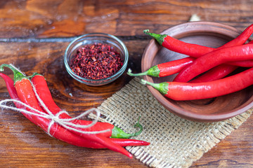 Hot red chili peppers on a wooden surface. Spicy additive in dishes.