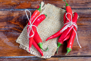 Hot red chili peppers on a wooden surface. Spicy additive in dishes.