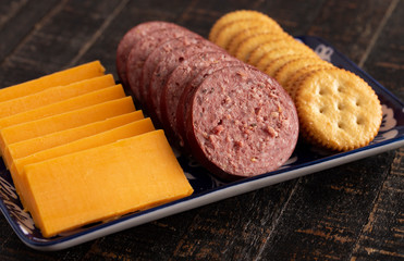 Summer Sausage Crackers and Cheddar Cheese on a Rustic Wooden Table
