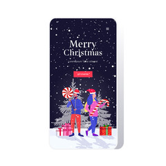 mix race couple in santa claus hats holding sweetmeats candy cane and lollipop merry christmas happy new year winter holidays celebration concept smartphone screen online mobile app full length vector