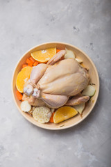 Whole raw chicken in  pan with orange, spice . Ready to cook. Cooking background. Copy space