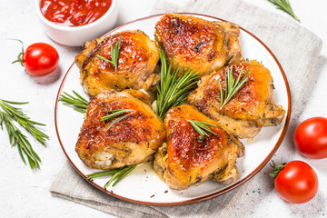 Baked chicken thighs with herbs on white plate.
