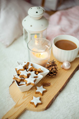 Christmas cookies stars, cocoa on a wooden board. Christmas decor, candles, plaid.
