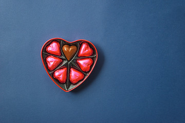 Romantic Valentines day concept. Gift box shape heart with chocolates on the blue background. Copy...