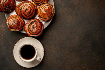 coffee and a lot of buns with poppy seeds on a stone background with copy space for your text