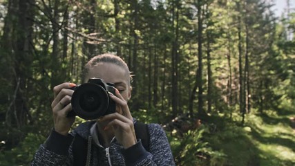 Traveler photographing scenic view in forest. One caucasian woman shooting close up look. Girl take photo video on dslr mirrorless camera. Professional photographer travel with backpack. Outdoor. - Powered by Adobe