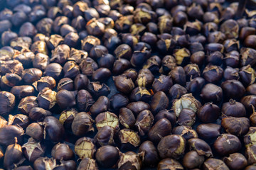 chestnuts roasted on the fire from a street vendor on the road in winter