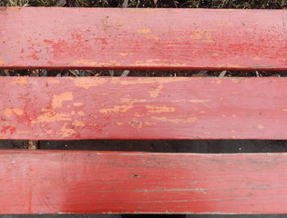 old shabby red painted park bench boards