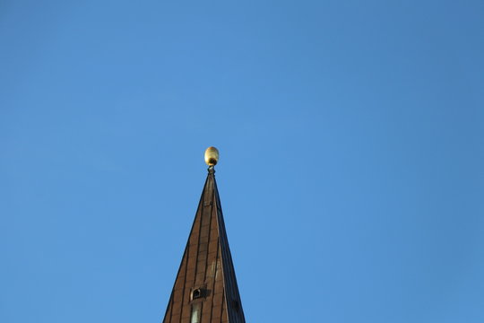 Golden church spire with clear blue sky background and copy space