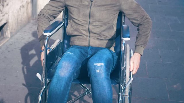 young disabled man pushing his wheelchair with his hands.handicaps, autonomy