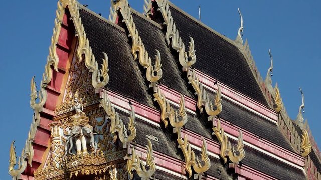 The decorated roof of Buddhist temple Nong Kae, Thailand. Traditional architecture - narrow monastery building, Thai countryside.
