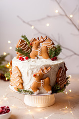Homemade Christmas cake with gingerbread decorations on a grey background. New Year decor - 309001626