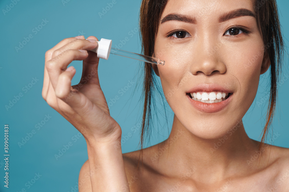 Canvas Prints portrait of half-naked asian woman holding dropper and smiling