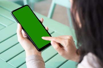 A woman and green screen on black smartphone