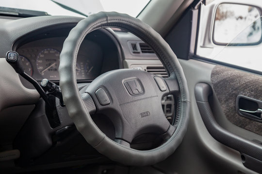 View to the inerior of Honda CR-V first generation with front seats, steering wheel and dashboard after cleaning before sale in a winter day and snow background