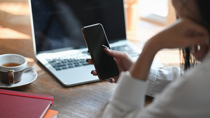 Fototapeta premium Cropped shot female using her mobile phone.