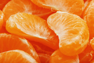 Slices of juicy tangerines close up as background texture.