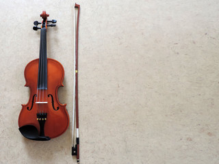 Classical red violin with bow on gray background. Classical musical instrument. Top view. Copyspace for text. © Vlyaks
